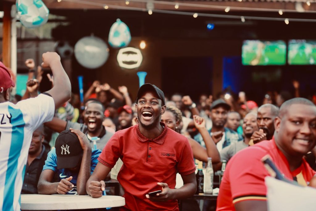 pexels-photo-14856235 A lively group of fans enthusiastically cheering at a sports bar during a live match.